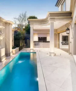 White Limestone tiles around an elegant blue pool.